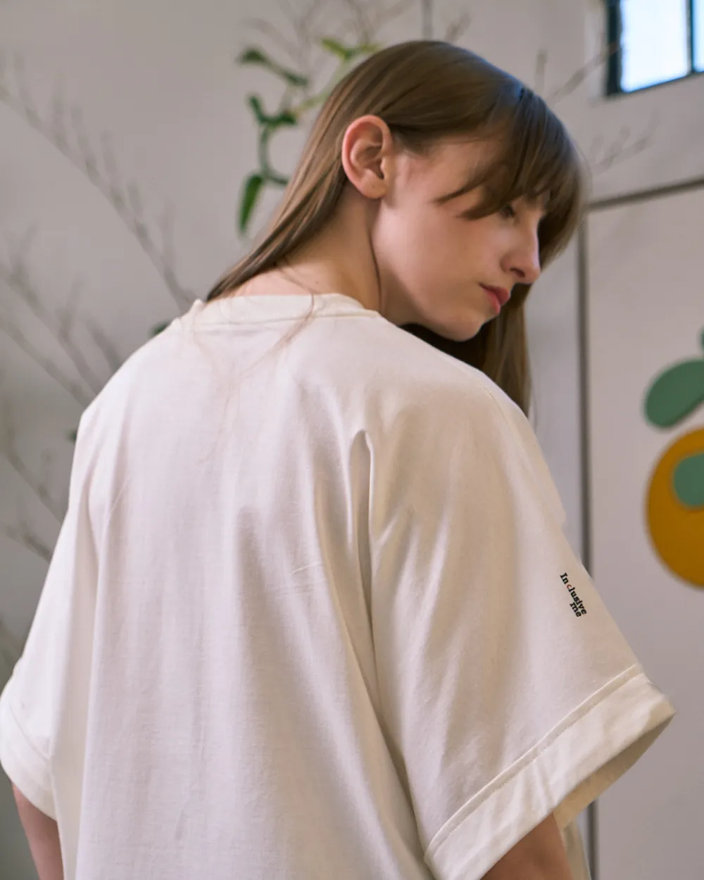 Costas e ombro da camiseta, com a marca impressa em pequeno na manga.