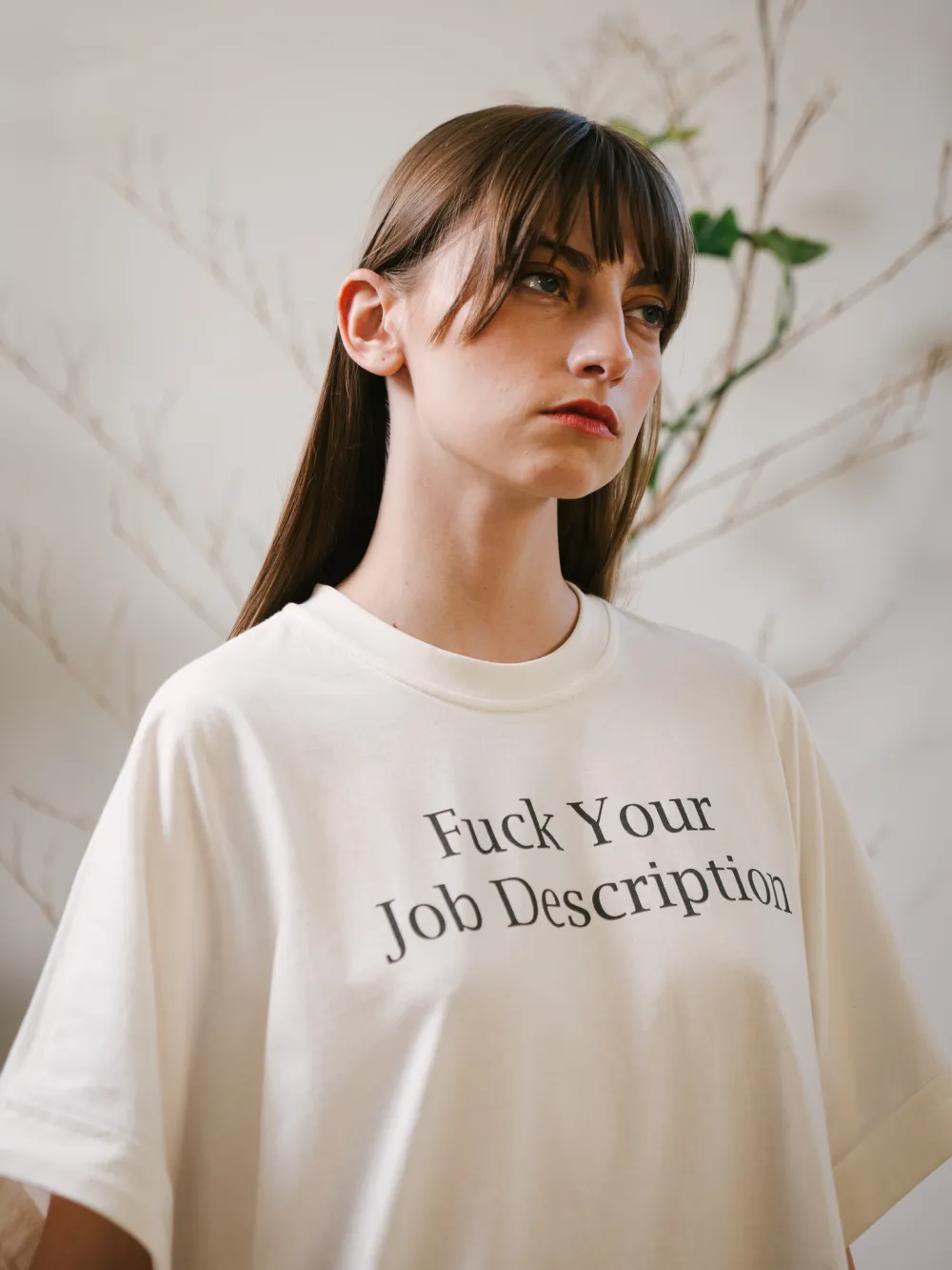 Retrato de frente com a camiseta off-white e a estampa legível no peito.